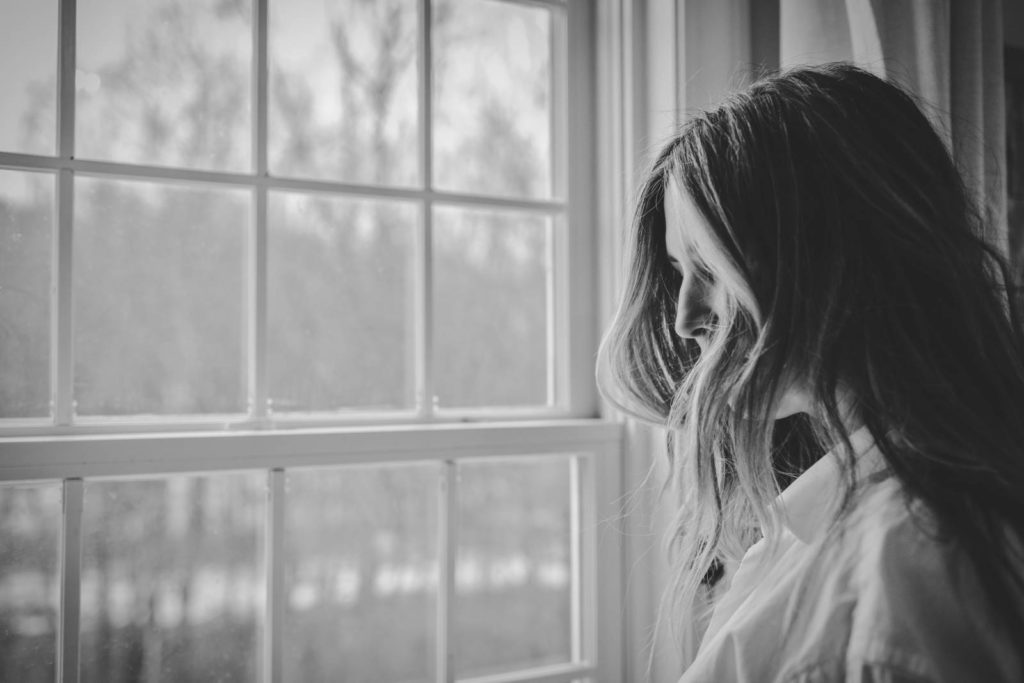 Woman with eating disorder stares out window