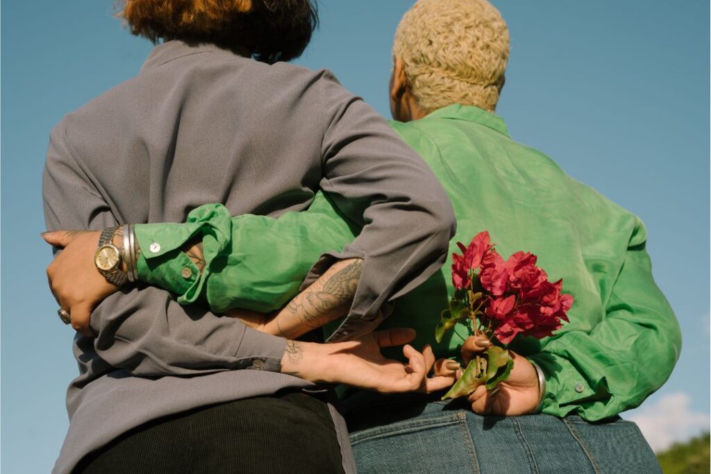 A woman pleasing another woman with a kind gesture of giving flowers. 